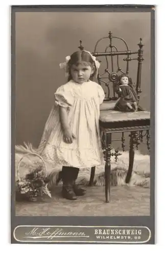 Fotografie M. Hoffmann, Braunschweig, niedliches Mädchen im weissen Kleidchen mit ihrer Puppe