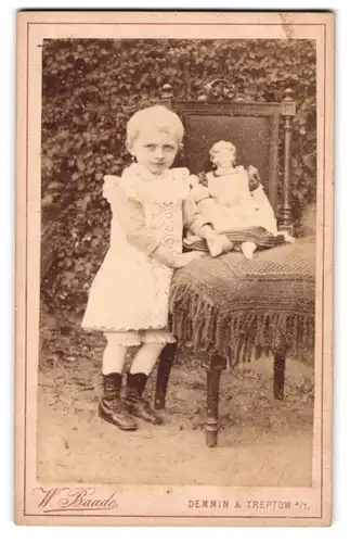 Fotografie W. Baade, Demmin, Portrait blondes Mädchen im weissen Kleid mit Puppe auf dem Stuhl