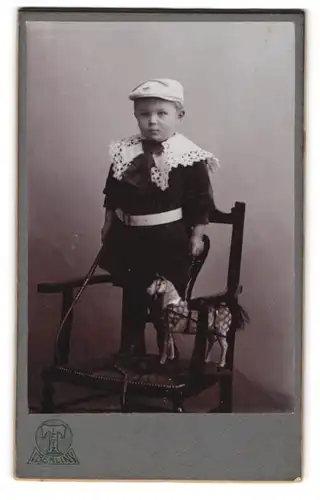 Fotografie Hermann Tietz, Berlin, kleines Kind im Samtkleid mit Spielzeugpferd und Peitsche