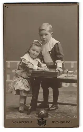 Fotografie Hans Rupprecht, Bremen, Portrait Geschwister in Kleidern mit Mühlebrett auf dem Tisch