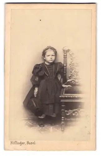 Fotografie Atelier Höflinger, Basel, Mädchen im schwarzen Kleidchen hält Hut in der Hand