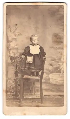 Fotografie H. Passow, Fuerstenwalde, Kleinkind mit Latz & Handtasche im schwarzen Kleidchen