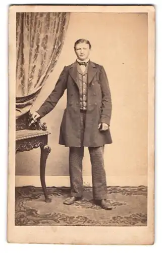 Fotografie unbekannter Fotograf und Ort, Bursche im karierten Anzug mit Mantel