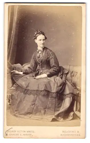 Fotografie Sydney Victor White, Reading, Portrait englische Dame im Reifrockkleid mit Haarschleife