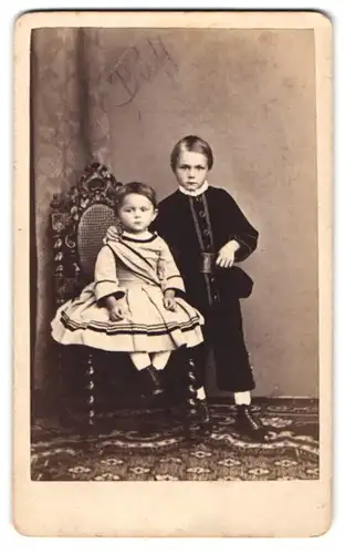 Fotografie Hans Stix, Giessen, Portrait zwei junge Geschwister im Kleid und im Anzug auf einem Stuhl sitzend