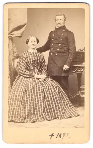 Fotografie E. Rose, Voigtstieg, Soldat in Uniform nebst Frau im karierten Kleid posieren im Atelier