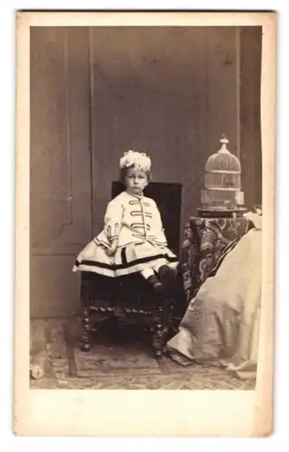 Fotografie J. Schäfer, Frankfurt a. M., Hochstr. 40, kleines Mädchen im hellen Kleid sitzt auf Stuhl neben Vogelkäfig