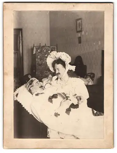 Fotografie unbekannter Fotograf und Ort, Fütterung des Wunderkindes, Travestie, 1909