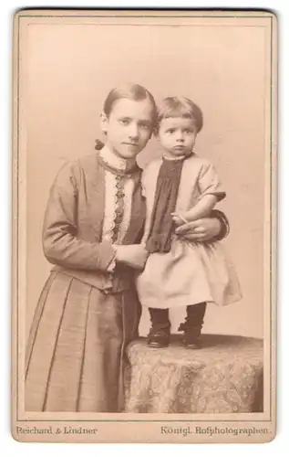 Fotografie Reichard & Lindner, Berlin-NW, Unter den Linden 54-55, Junges Mädchen mit kleinem Kind in modischer Kleidung