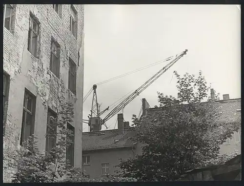 Fotografie unbekannter Fotograf, Ansicht Berlin-Friedrichshain, Hinterhof mit bröckelnder Fassade, Seilkran