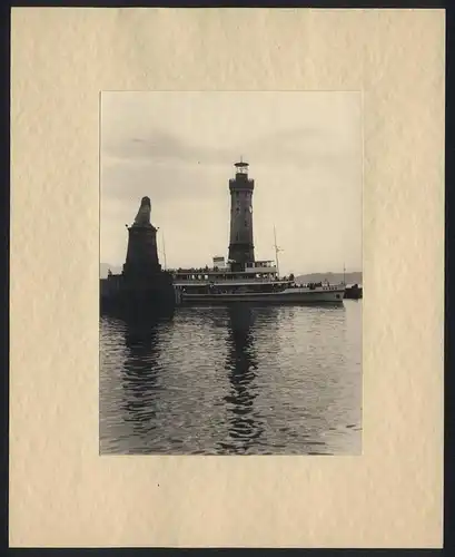 Fotografie unbekannter Fotograf, Ansicht Lindau / Bodensee, Dampfer Baden passiert die Hafeneinfahrt, Leuchtturm um 1939