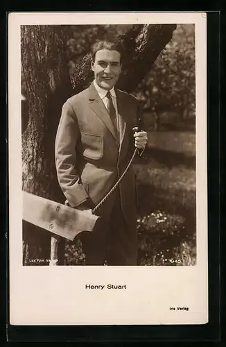 AK Schauspieler Henry Stuart steht lächelnd in einem Park