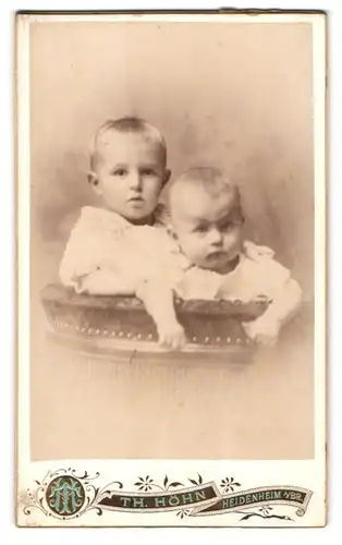 Fotografie Th. Höhn, Heidenheim a. Br., Grabenstr., Portrait zwei süsse blonde Kleinkinder in weisser Kleidung
