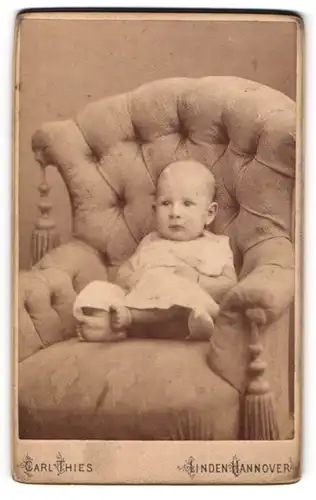 Fotografie Carl Thies, Hannover-Linden, Deisterstr. 2, Portrait süsses Baby liegt in einem Sessel