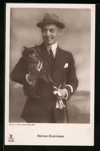 AK Schauspieler Bruno Kastner im Anzug mit Hut und einem Hund im Arm