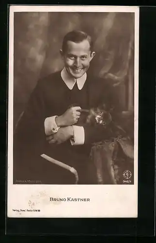 AK Schauspieler Bruno Kastner mit Hund in den Armen in die Kamera lächelnd