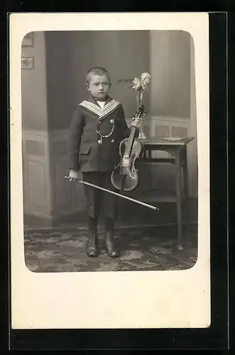 AK Knabe im eleganten Anzug hält seine Geige in der Hand