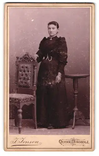 Fotografie J. Jensen, Quern-Dingholz, Frau im schwarzen Kleid an Stuhl abstützend