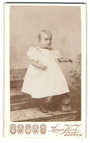 Fotografie Louis Koch, Bremen, Auf der Brake 20, Kleines Kind mit kurzen Haaren im weiten Kleidchen