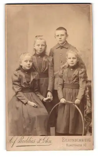 Fotografie C. F. Beddies & Sohn, Braunschweig, Kuhstr. 10, Knabe und drei Mädchen in modischer Kleidung mit Reifen