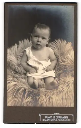Fotografie Max Hoffmann, Braunschweig, Wilhelmstr. 88, Süsses Kleinkind im Hemd sitzt auf Fell