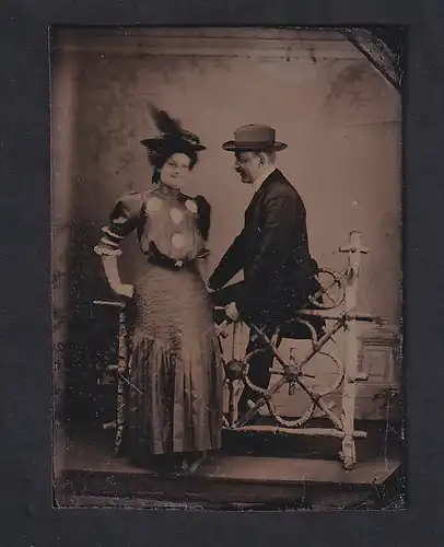 Fotografie Ferrotypie Fotograf unbekannt, Paar elegant gekleidet mit Hut im Foto-Atelier