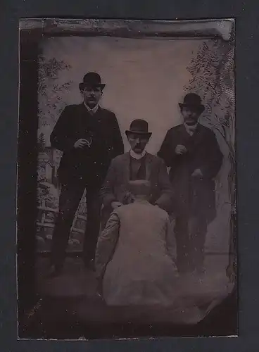 Fotografie Ferrotypie Fotograf bei Vorbereitung der Aufnahme von Drei Herren im Anzug mit Hut Melone