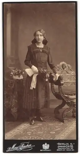 Fotografie Max Fischer, Berlin, Portrait junge Frau im dunklen gerafften Kleid mit Halskette und Haarschleife