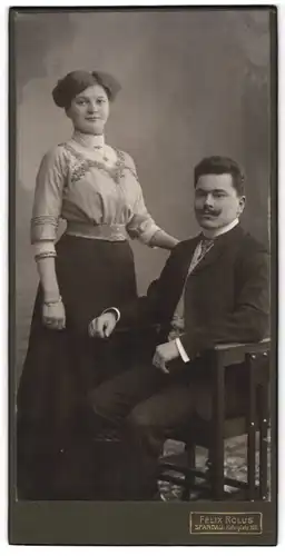 Fotografie Felix Rolus, Spandau, Portrait junges Paar im Anzug und im schwarzen Rock mit heller Bluse