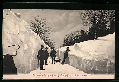 AK Freiberg, Schneeverwehung auf der Freiberg-Brüxer Staatsstrasse - Passanten mit Hund im Schneegraben