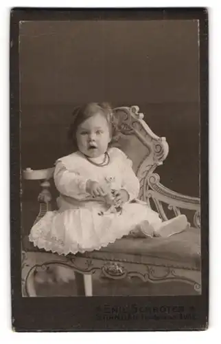 Fotografie Emil Schröter, Berlin-Spandau, Potsdamer-Str. 31-32, Süsses Kleinkind im Kleid mit Spielzeugkuh