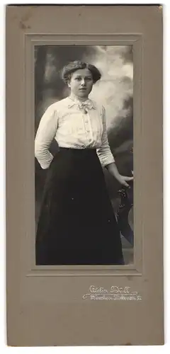Fotografie Atelier Düll, München, Türkenstr. 31, Dame in heller Bluse an einem Stuhl stehend