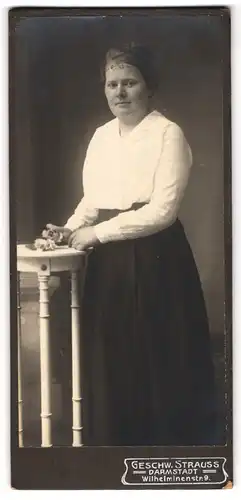 Fotografie Geschw. Strauss, Darmstadt, Wilhelminenstr. 9, Dame an einem Tisch mit Blume