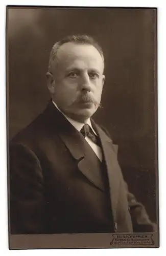 Fotografie Hugo Stöppler, Bünde i. W., Bahnhofstrasse, Herr im Anzug mit Schnauzer