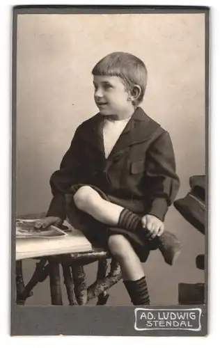 Fotografie Ad. Ludwig, Stendal, Junge im Matrosenanzug mit einem Buch