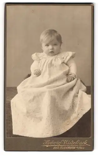 Fotografie Hedwig Wisselinck, Bad Suderode / Harz, Kleinkind im übergrossen, weissen Kleidchen