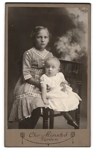 Fotografie Chr. Mönsted, Verden, Kleines Mädchen mit ihrem neugeborenen Geschwisterchen im Arm