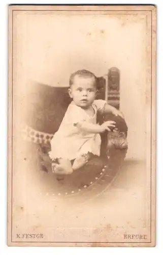 Fotografie K. Festge, Erfurt, Anger 51, Niedliches Kleinkind auf einem Polsterstuhl