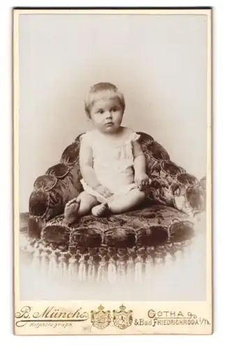 Fotografie B. Münchs, Gotha i. Th., Süsses Kleinkind auf einem Samtpolster