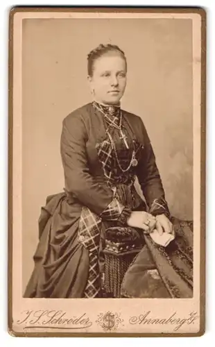 Fotografie J. S. Schrölder, Annaberg i. S., Carlsplatz 756, Junge Frau mit karierten Einsätzen am Kleid