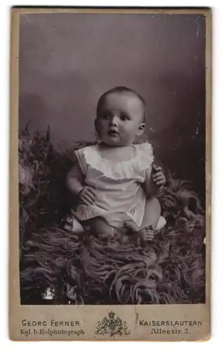 Fotografie Georg Ferner, Kaiserslautern, Alleestr. 3, Süsses Kleinkind im Hemd sitzt auf Fell