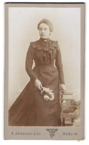 Fotografie A. Jandorf & Co, Berlin, S. W. Belle-Alliance-Str. 1 & 2, Dame im schwarzen Kleid mit Blumenbouquet