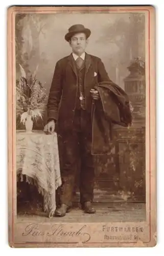 Fotografie Pius Straub, Furtwangen, Rabenstrasse 9, Herr mit Hut und Anzug an Tisch stehend