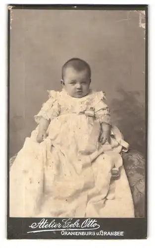 Fotografie Gebr. Otto, Oranienburg, Säugling im Taufkleid