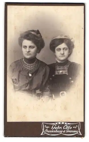 Fotografie Gebr. Otto, Oranienburg, Portrait Schwestern im Sonntagskleid mit Schmuck & Haarband