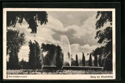 AK Burg b. Magdeburg, Bahnhofs-Anlagen, Wasserfontäne und Zypressen im Wind