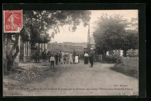 AK Herme, Rue de la Gare et le passage á niveau, au loing l`Usine des Grands Pleux