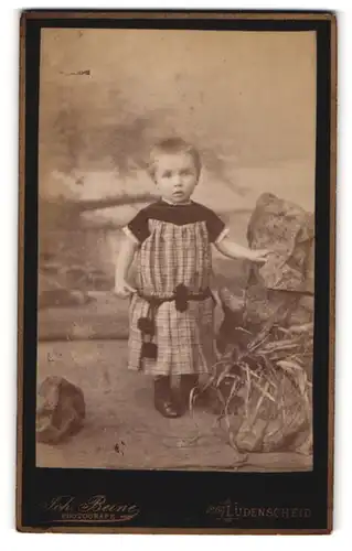 Fotografie Joh. Beine, Lüdenscheid, Altenaerstrasse 12, Kleinkind mit kurzen Haaren im Kleidchen mit Bommeln