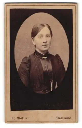 Fotografie Th. Möller, Stralsund, Franken-Strasse 5, Junge Frau mit Scheitel und Brosche in dunklem Kleid