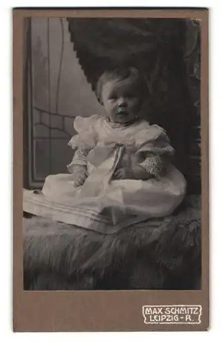 Fotografie Max Schmitz, Leipzig-R., Weidmannstrasse 2, Baby im Taufkleid auf einem Fell